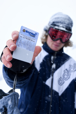 A snowsports rider holds up his Brighton lift ticket bought with a gift card